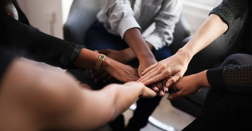 Team putting all hands in a circle