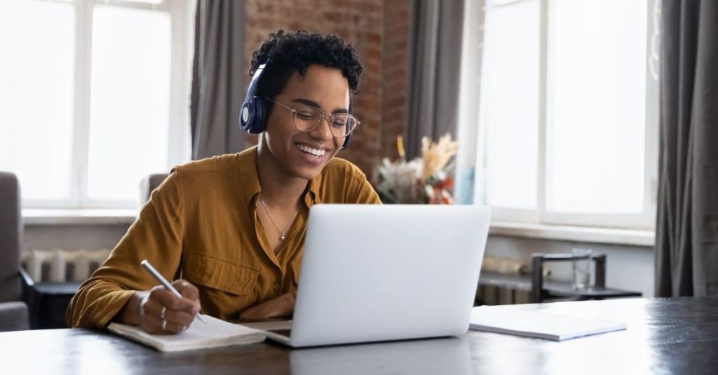 Person smiling at computer screen