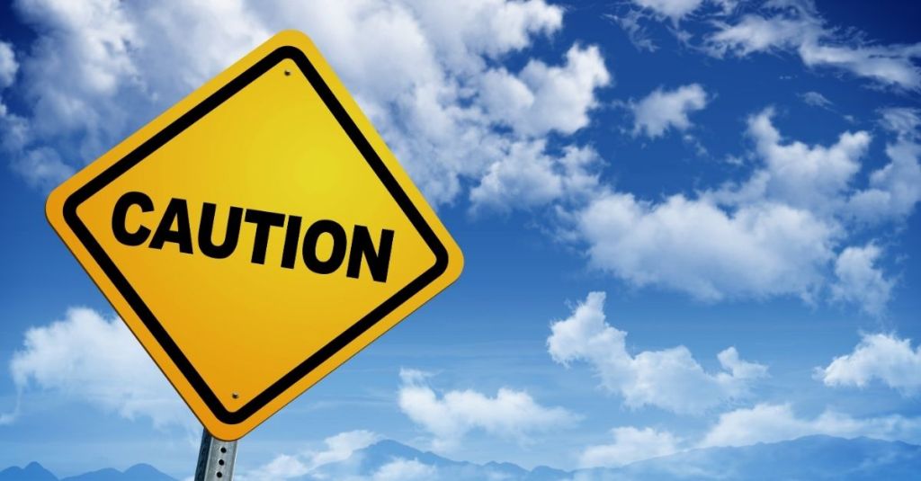 Yellow caution sign with blue sky in the background