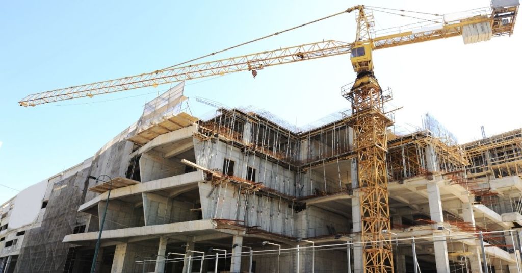 Crane hovering over the construction of a commercial building