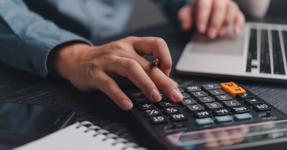 Person typing on a calculator
