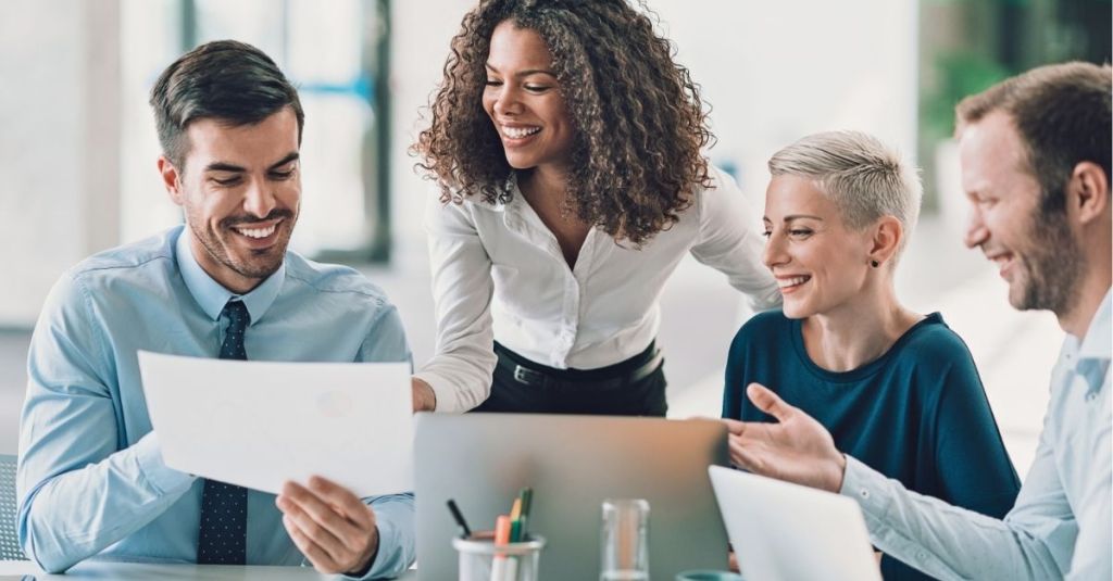 Four coworkers smiling and laughing together