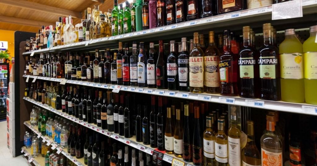 Wine and liquor bottles lined up on grocery store shelves