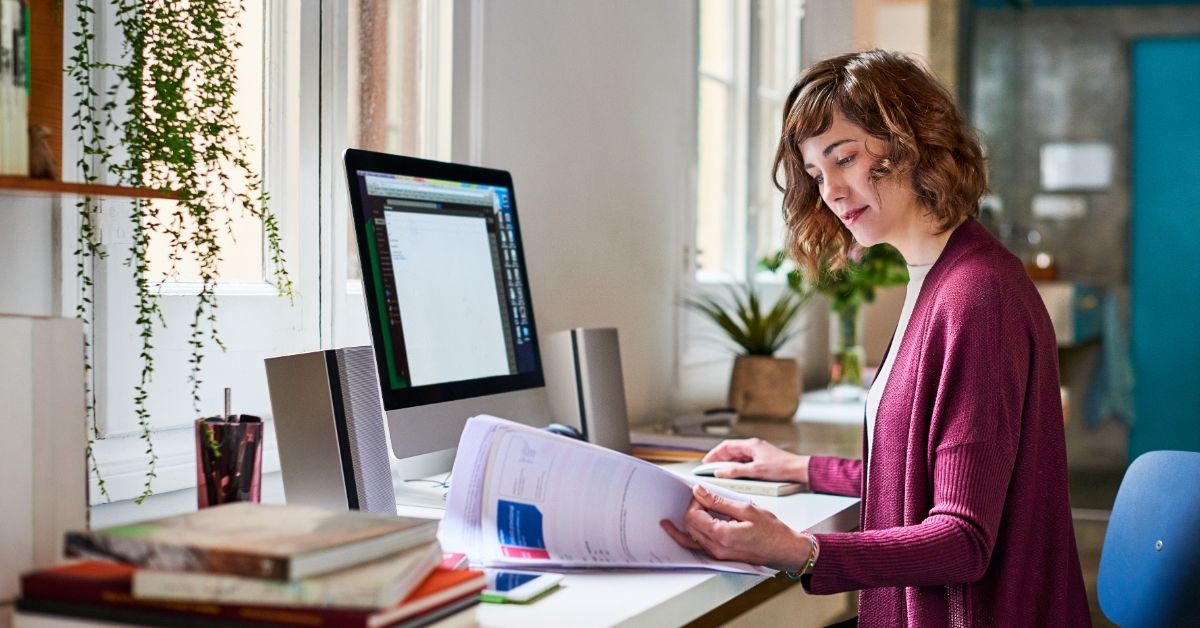 Woman sitting at a desk looking at documents