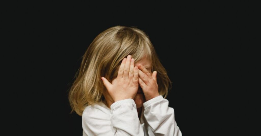 Child covering her face
