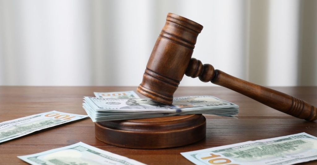 Wooden gavel laying on a stack of money