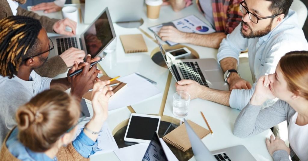 Team members speaking to one another at a table
