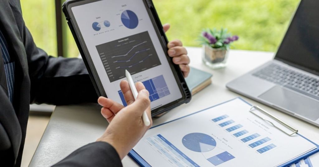 Person pointing at graph on tablet