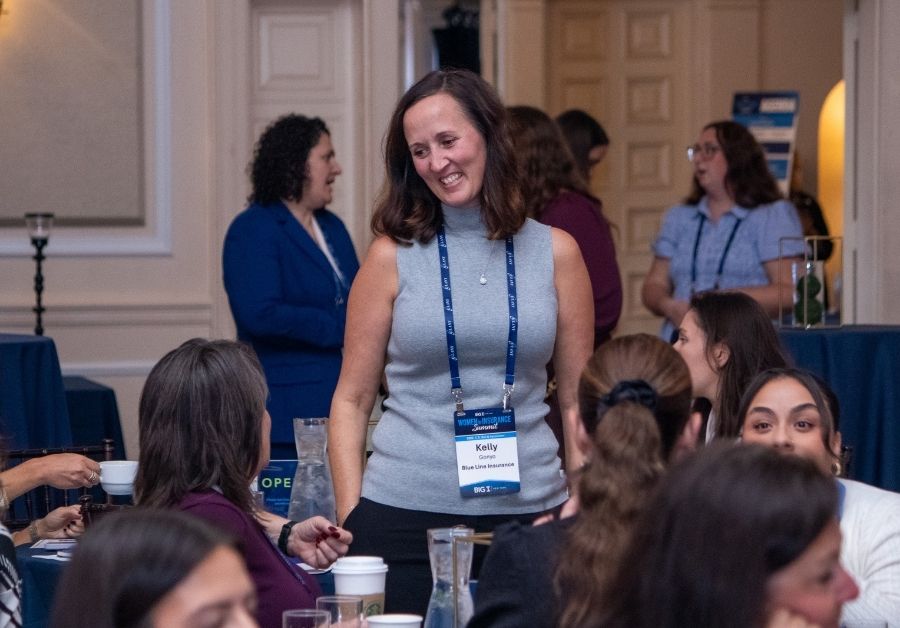 Kelly Gonyo of Blue Line Insurance Agency laughing and smiling in conversation with another woman at the Big I NY Women in Insurance 2026.