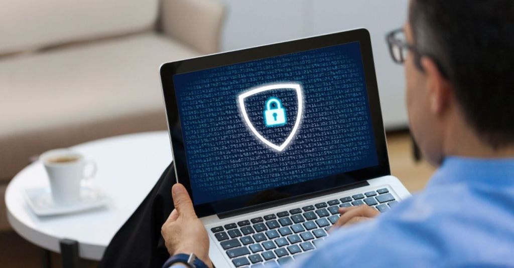 Man looking at computer screen with lock and shield icon displayed