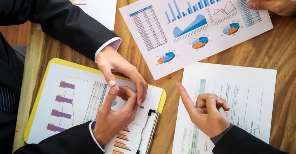 Two people looking over charts and graphs