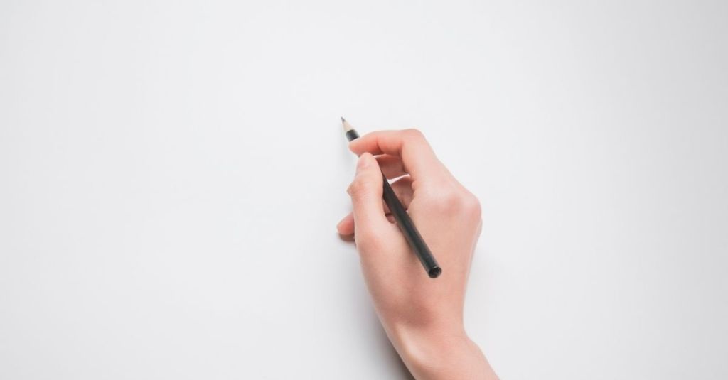 Person writing on a blank piece of paper