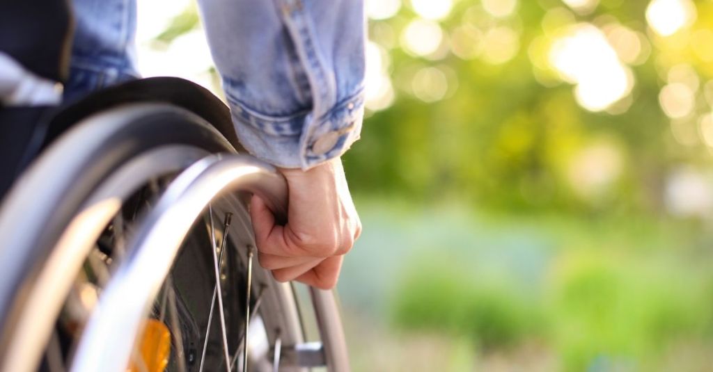 Person turning the wheels in a wheelchair