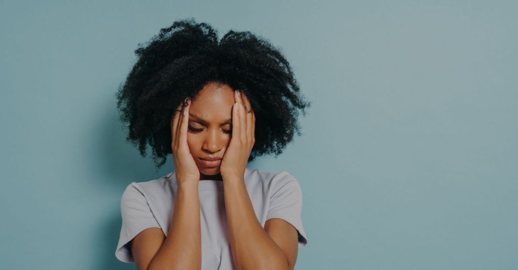 Woman looking frustrated with her hands on her face
