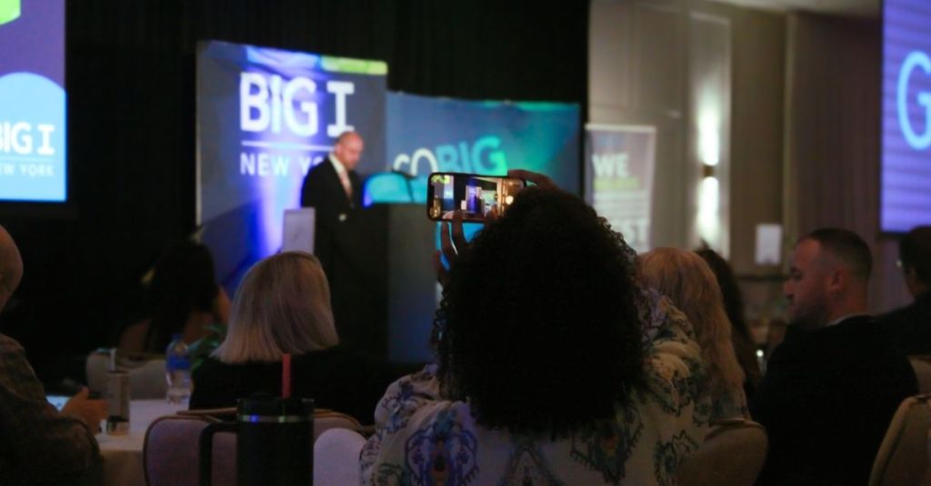 Person taking picture of speaker at Go Big 2024