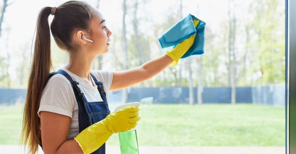 Housekeeper cleaning a window