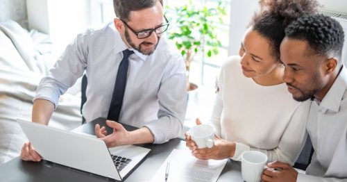 An insurance agent talking to a man and woman couple.