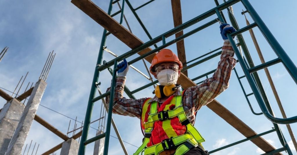 Construction worker walking across scaffolding