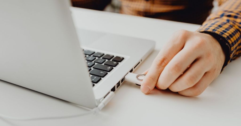 Person inserting USB file into laptop port