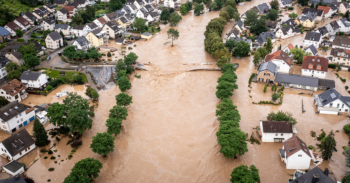 Red umbrella hanging over a piggy bank and house figure