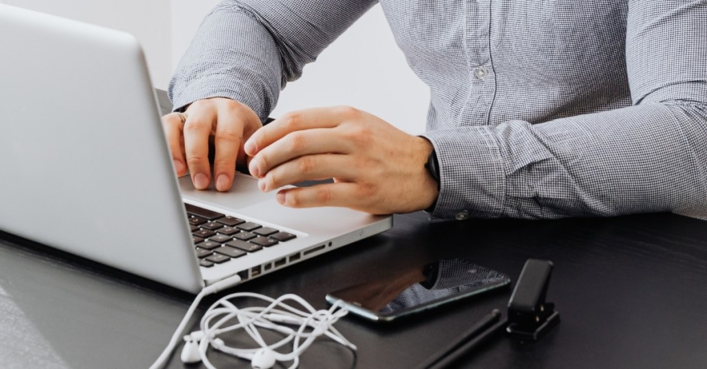 A man sitting at a table working on a computer