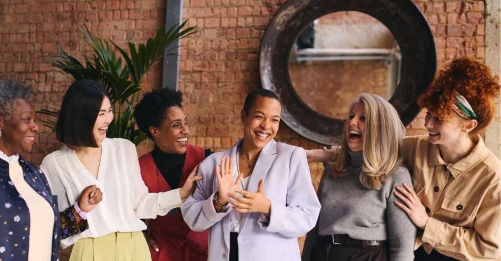 A group of women smiling and laughing amongst each other other