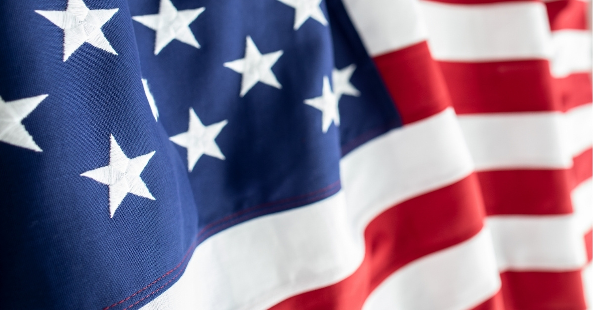A close-up view of the American flag waving in the air.