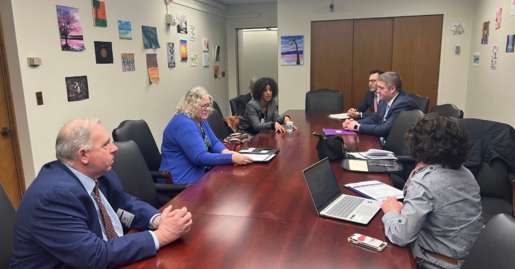 Big I NY members and legislators talking at a table at the G100 Day on the Hill 2026.