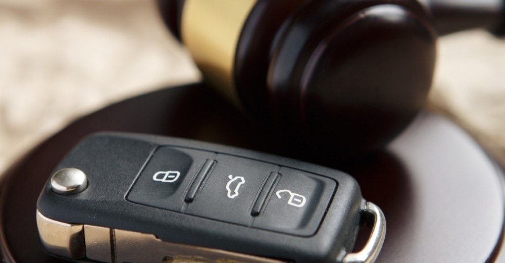 A set of car keys lying beside a gavel.